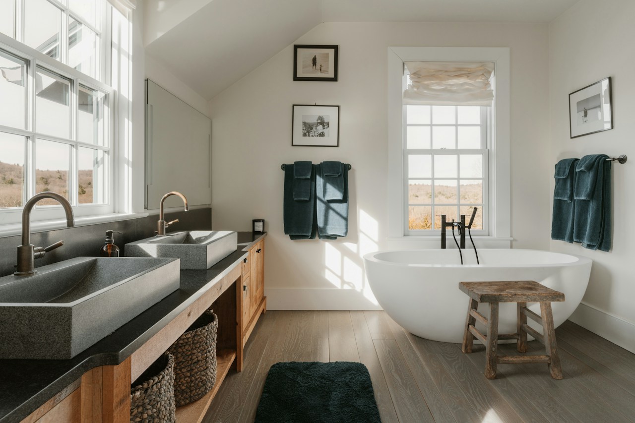 Bright bathroom with a freestanding bathtub and double vanity, in a plumbing website concept.