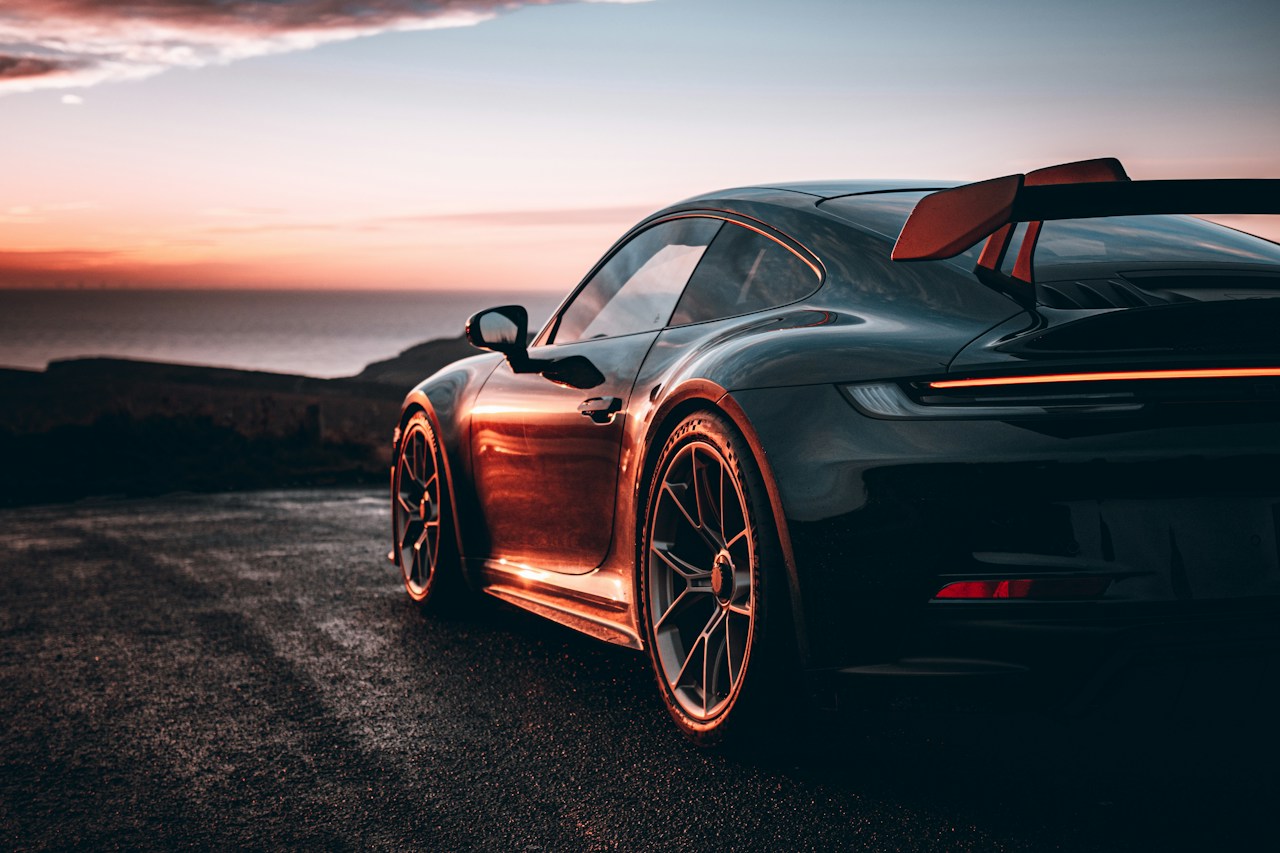 Black performance sports car at sunset, used in an automotive workshop concept website.