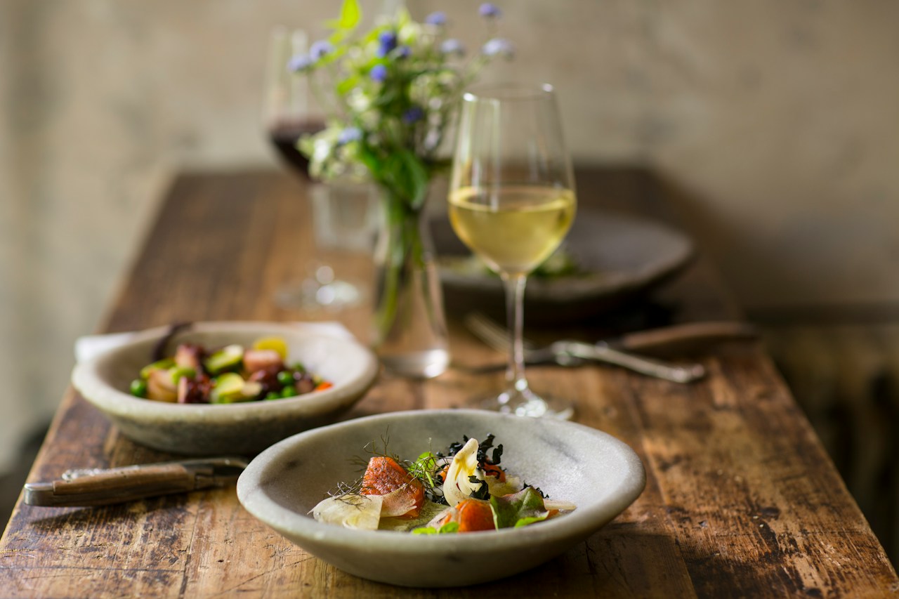 Artisan dishes on ceramic plates on a rustic restaurant table, in a hospitality concept.